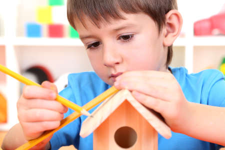 Cute little boy makes birdhouse for birdsの写真素材