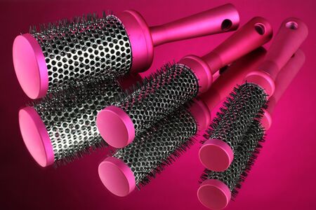 Comb brushes on pink backgroundの写真素材
