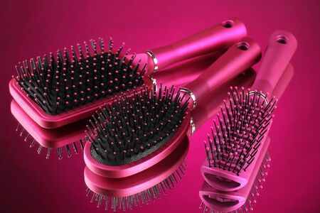 Comb brushes on pink backgroundの写真素材
