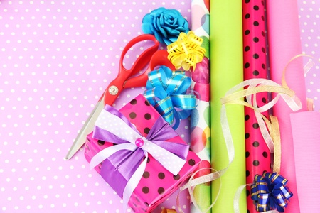 Rolls of Christmas wrapping paper with ribbons, bows on color backgroundの写真素材