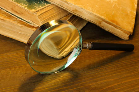 Magnifying glass and books on tableの写真素材