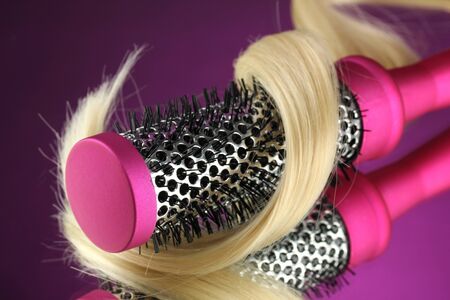 Comb brush with hair on purple backgroundの写真素材