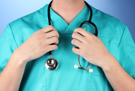 Doctor with stethoscope, on blue backgroundの写真素材