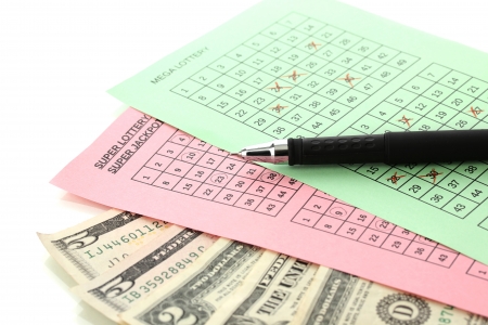 Lottery tickets with pen and money, isolated on whiteの写真素材