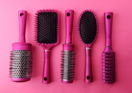 Comb brushes on pink backgroundの写真素材