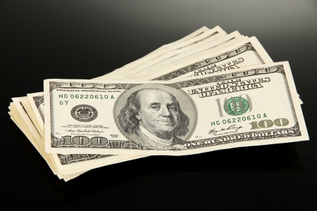 Stack of one hundred dollars banknotes close-up isolated on blackの写真素材