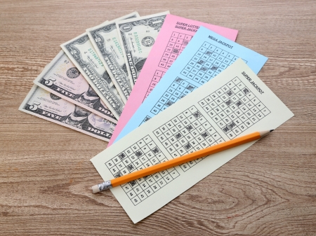 Lottery tickets with pencil and money, on wooden backgroundの写真素材