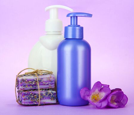 Liquid and hand-made soaps on purple backgroundの写真素材