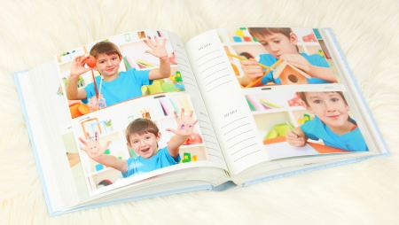 Open photo album with pictures on white carpetの写真素材