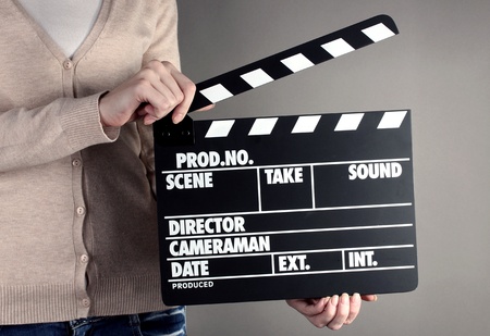 Movie production clapper board in hands on grey backgroundの写真素材