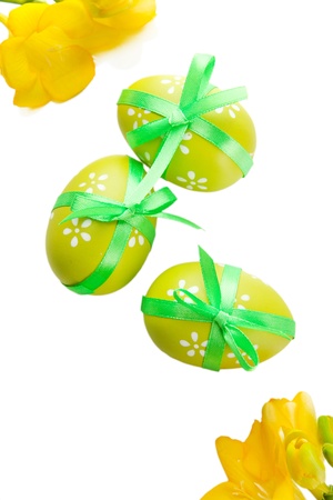Bright easter eggs with bow and flowers, isolated on whiteの写真素材