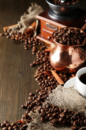Cup of coffee, pot and grinder on wooden backgroundの写真素材