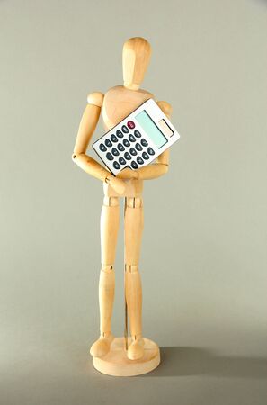 Wooden mannequin with calculator on grey backgroundの写真素材