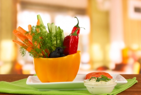 Assorted raw vegetables sticks in pepper bowl on wooden table on bright backgroundの写真素材