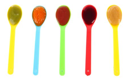 Baby puree in spoons isolated on whiteの写真素材