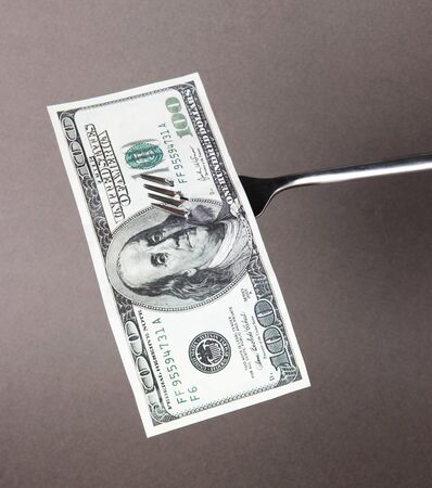 Banknotes on fork on grey backgroundの写真素材