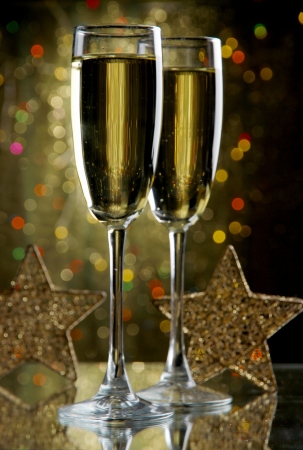 Two glasses of champagne on bright background with lightsの写真素材