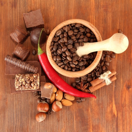 Chocolate sweets, mortar with coffee beans on wooden backgroundの写真素材