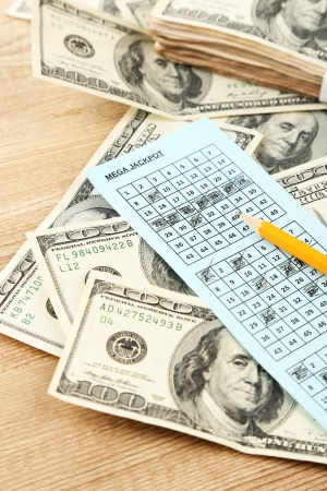 Lottery ticket,money and pencil on wooden backgroundの写真素材