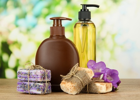 Liquid and hand-made soaps on wooden table, on green backgroundの写真素材
