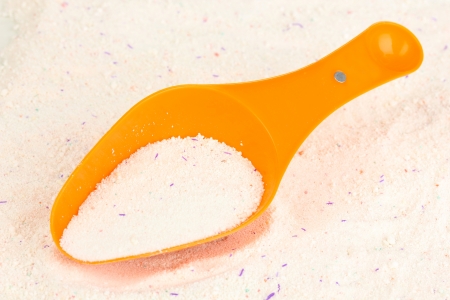 Washing powder in measuring cup on powder backgroundの写真素材