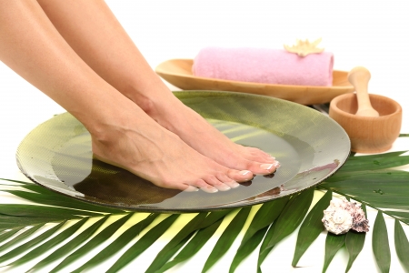 Female feet in spa bowl with water, isolated on whiteの写真素材