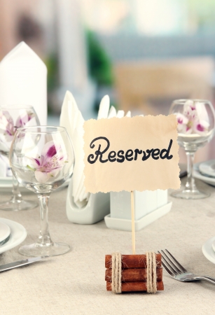 Reserved sign on restaurant table with empty dishes and glassesの写真素材