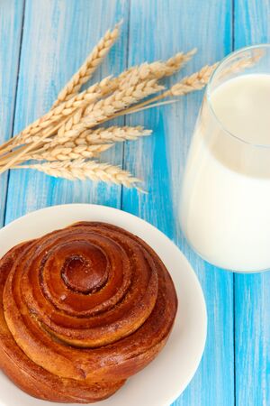 Bread roll and glass of milk on blue wooden backgroundの写真素材