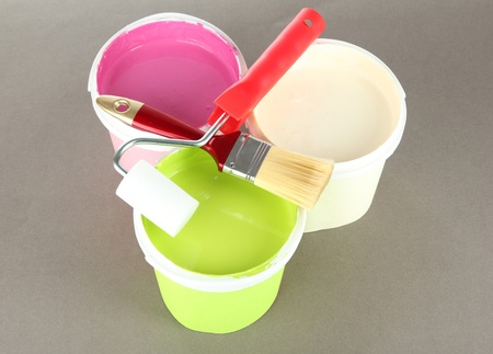 Set for painting: paint pot, brushes, paint-roller on grey backgroundの写真素材