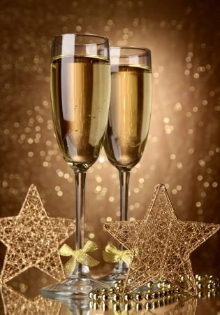 Two glasses of champagne on bright background with lightsの写真素材