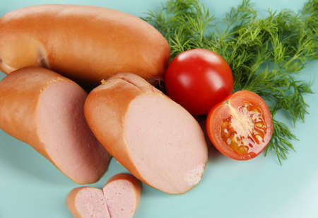 Sausage, greens, tomato on plateの写真素材