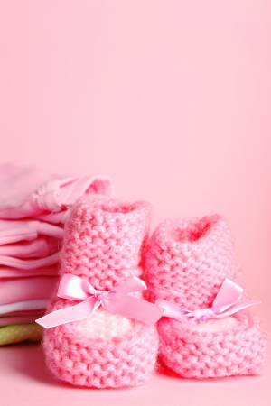 Pile of baby clothes on pink backgroundの写真素材