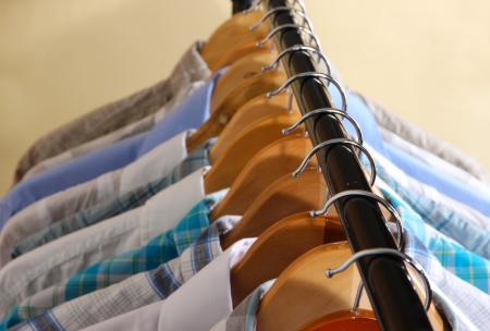 Men's shirts on hangers on beige backgroundの写真素材