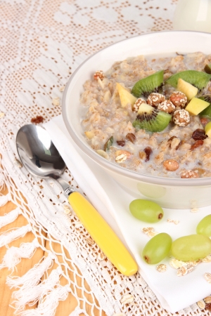 Useful oatmeal in bowl with fruit on wooden table close-upの写真素材