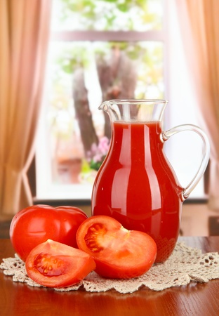 Tomato juice in pitcher on table on in roomの写真素材