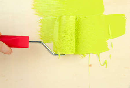 Paint roller brush with green paint, on wooden backgroundの写真素材