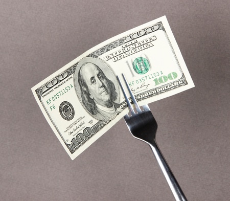 Banknotes on fork on grey backgroundの写真素材