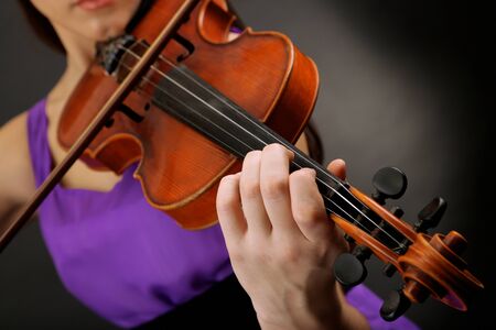 Beautiful young girl with violin on grey backgroundの写真素材