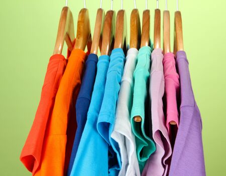Variety of casual shirts on wooden hangers,on blue backgroundの写真素材
