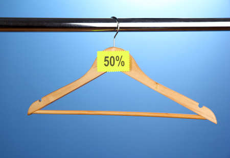 wooden clothes hanger as sale symbol on blue background
の写真素材