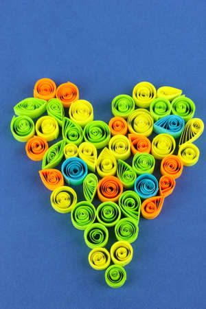 Colorful quilling laid out in form of heart on blue backgroundの写真素材