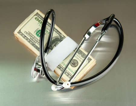 Healthcare cost concept: stethoscope and dollars on gray background