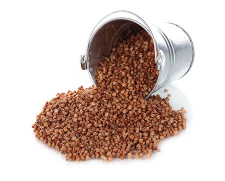 Overturned bucket with grains isolated on whiteの写真素材