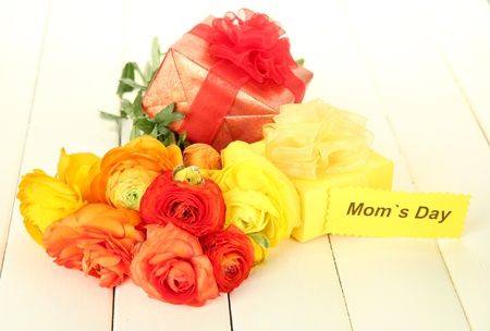 Ranunculus (persian buttercups) and gifts for mothers day, on white wooden backgroundの写真素材