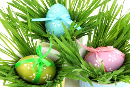 Easter eggs in bowl with grass on table close up
