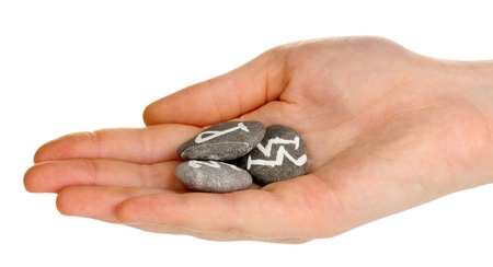 Fortune telling  with symbols on stone in hand isolated on whiteの写真素材