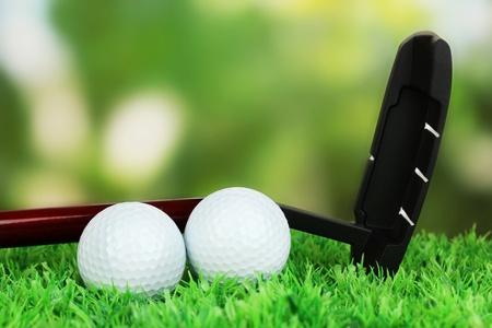 Golf balls and driver on green grass outdoor close upの写真素材