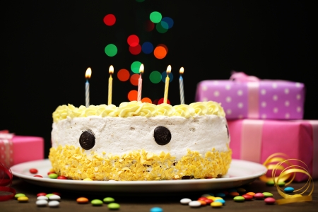 Happy birthday cake and gifts, on black backgroundの写真素材