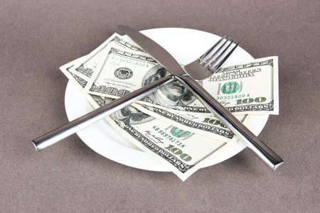 Money on plate on grey background
