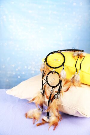Beautiful dream catcher and pillows on blue backgroundの写真素材